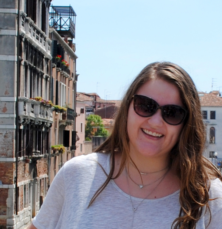 Taylor Pruitt, sophomore, a Hospitality Innovation and Agricultural Business double major poses in front of Italian homes while studying abroad.