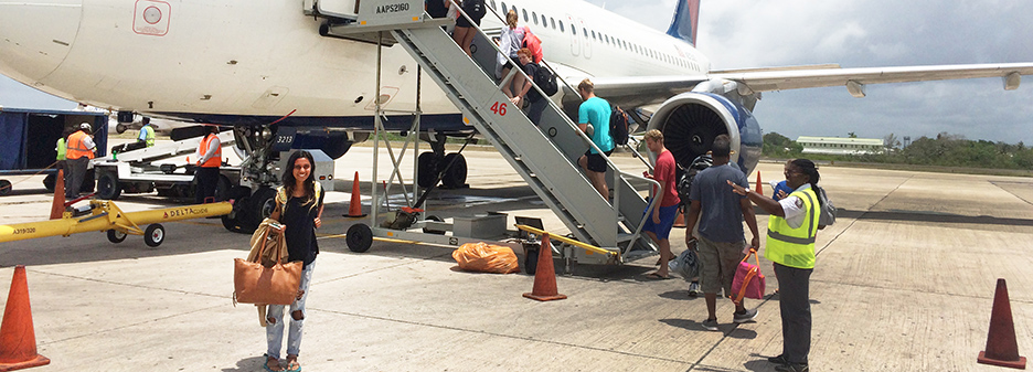 Student posing beside plane.